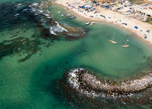 Turquoise water, breakwaters and a beach seen from above