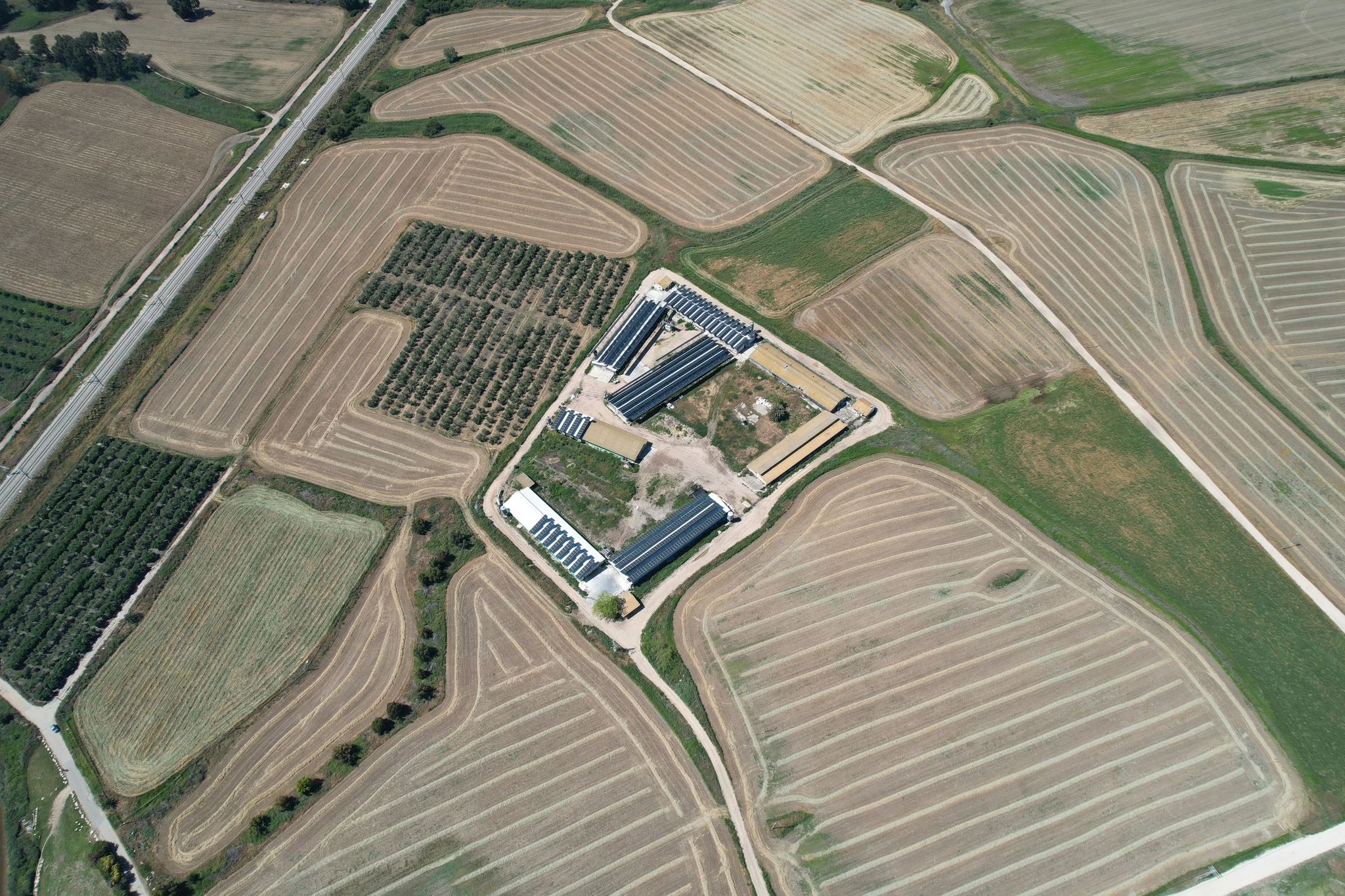 An aerial view of a building surrounded by agricultural fields