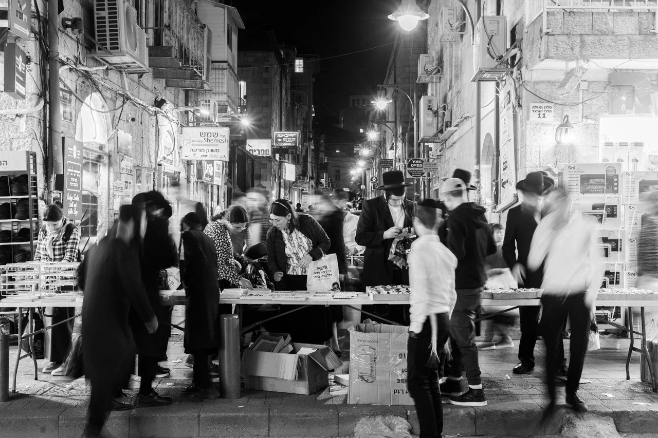 People gathered around a table on a city street at night
