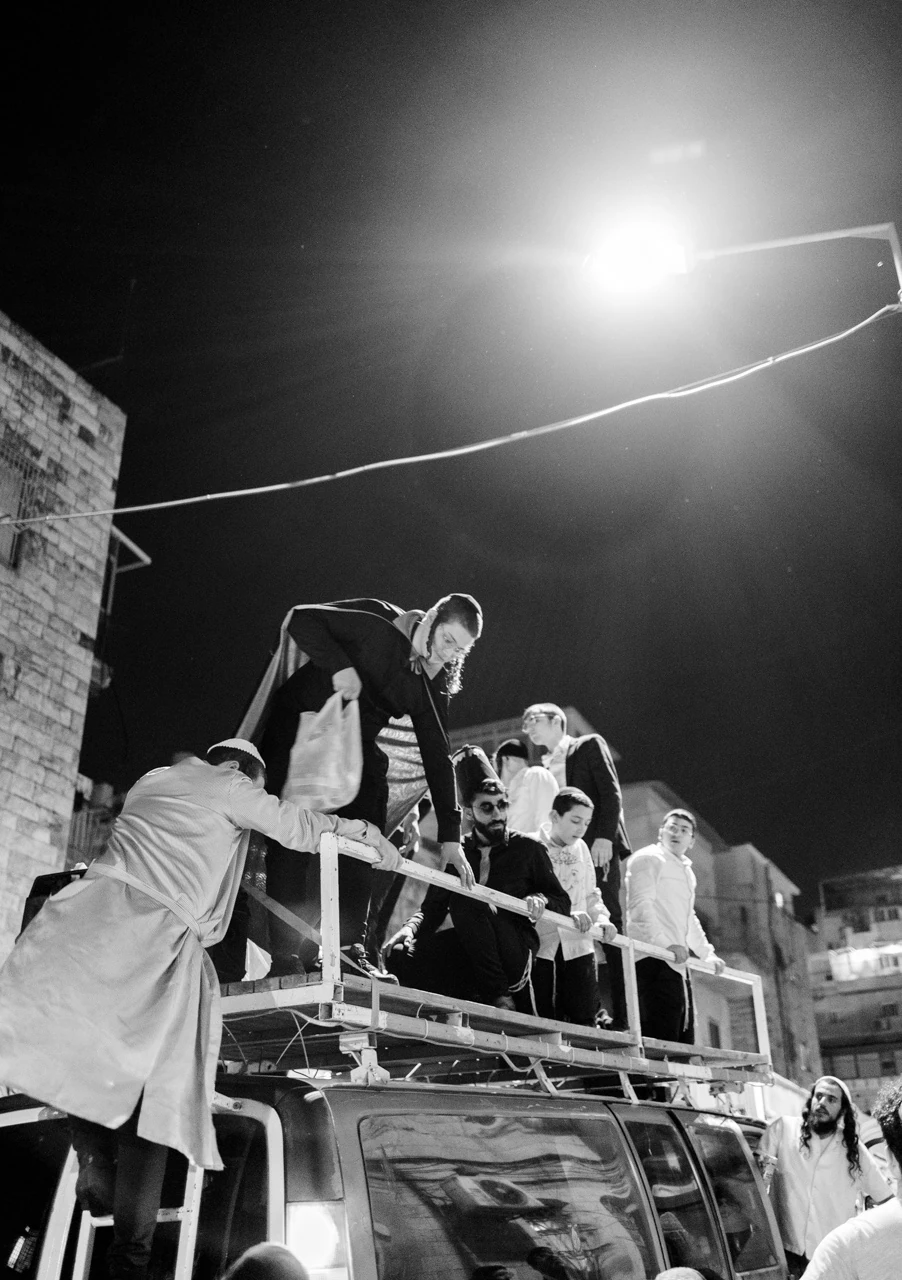 People beneath a bright streetlight at night