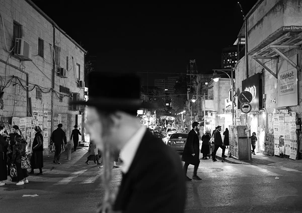 A figure in the foreground of a busy nighttime street