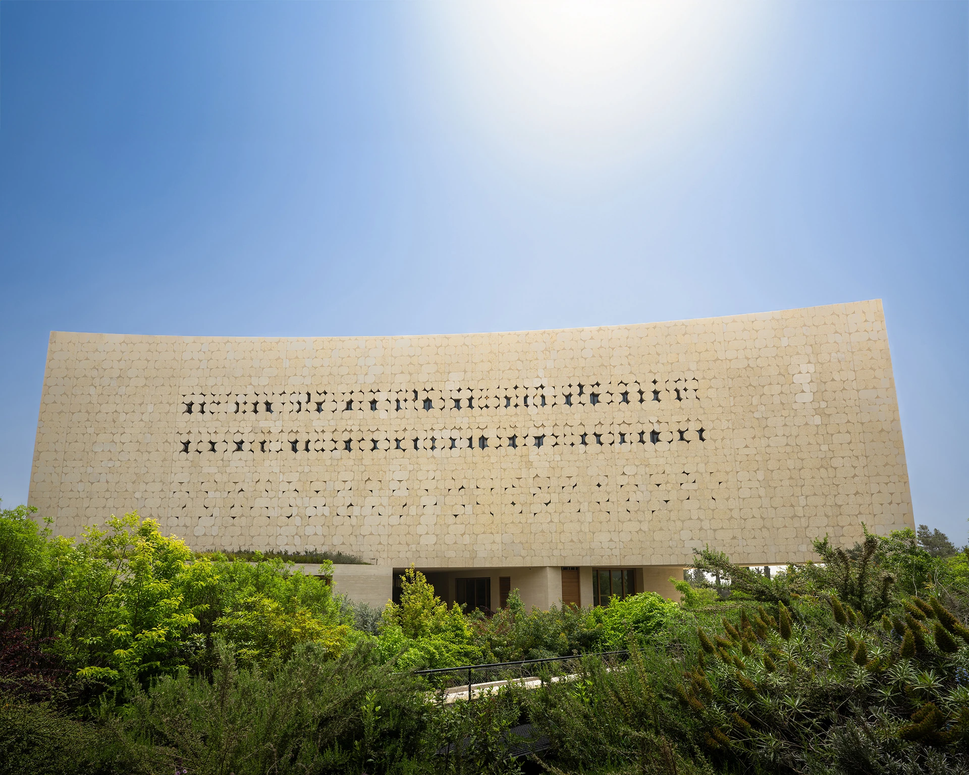 The library facade and lettering above green planting