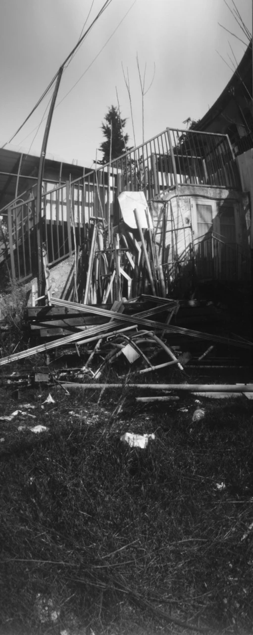 Soft black-and-white view of rails and a damaged structure