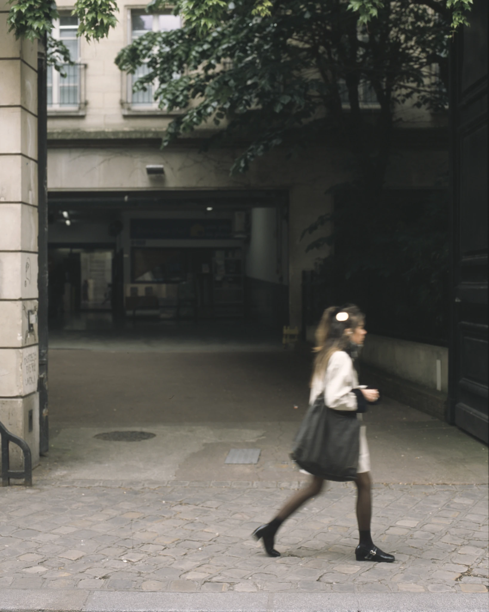 A pedestrian passing a shaded doorway