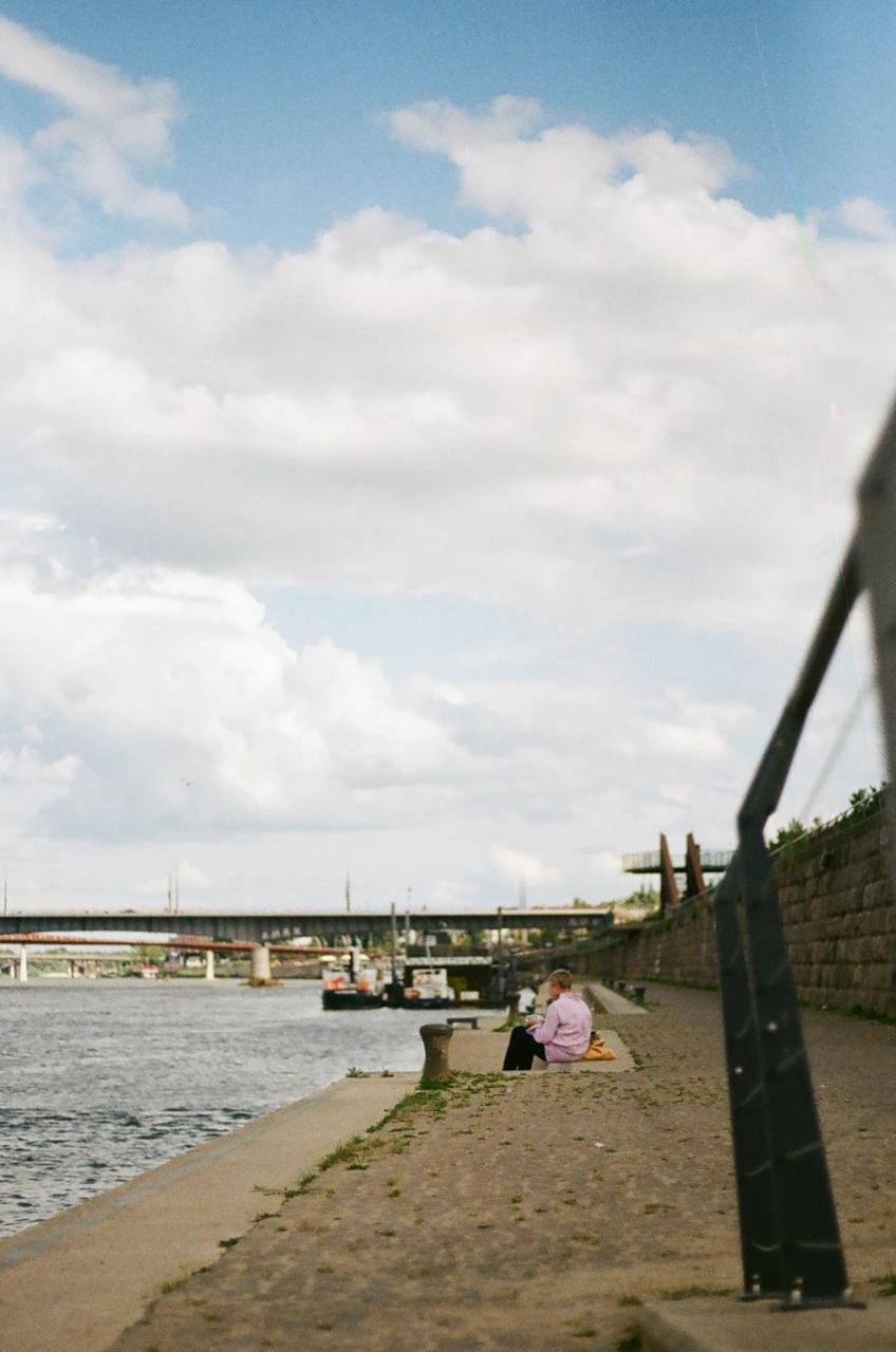 A path beside the river under a cloudy sky
