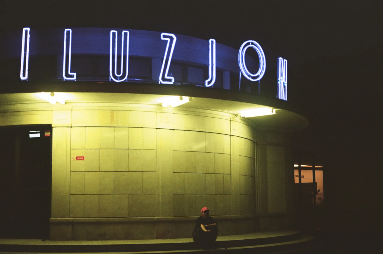 The illuminated Iluzjon cinema sign at night